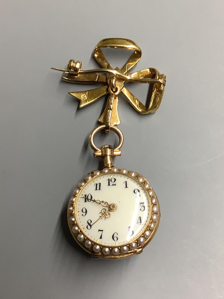 A lady's early 20th century yellow metal and seed pearl set fob watch, on a 18ct and seed pearl set bow brooch